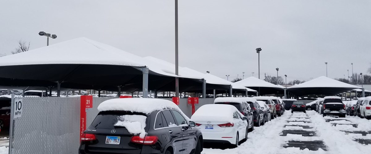 snow covered parking lot with cars thumbnail