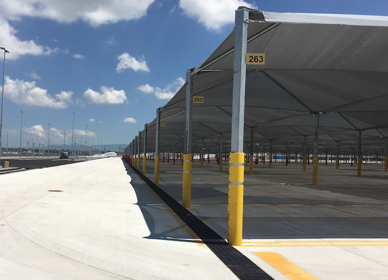 number signs attached to poles in a large shade structure for vehicles