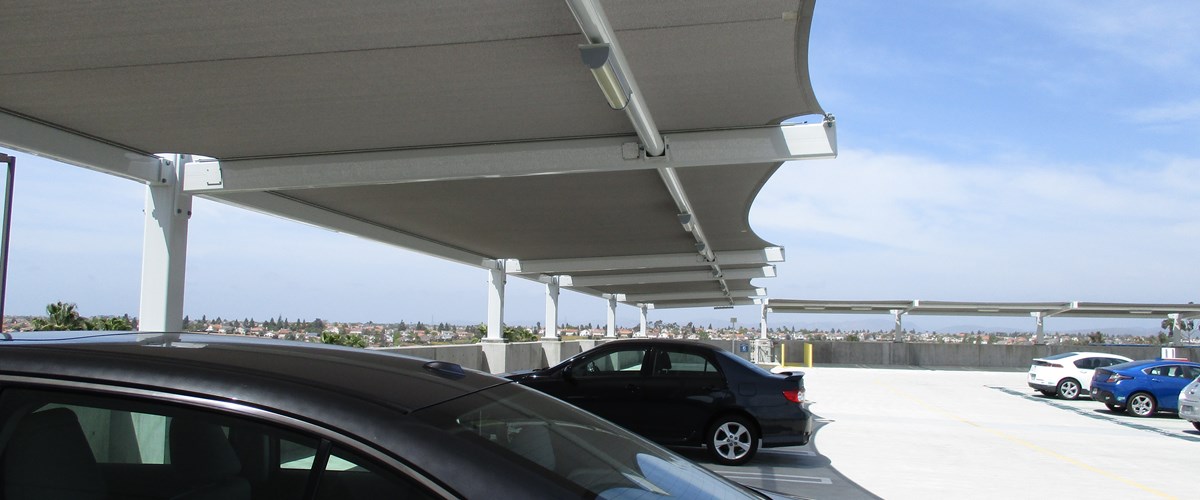 cars shaded by parking lot structure